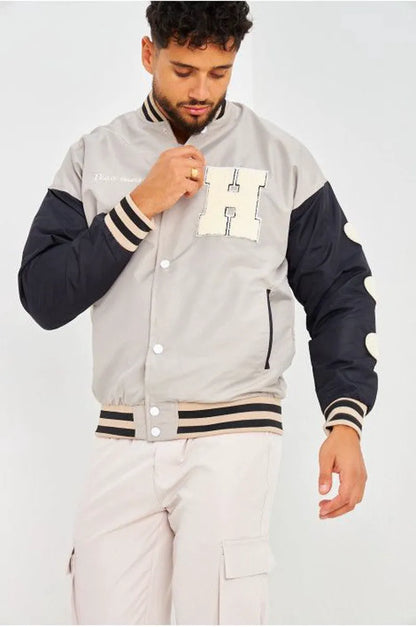 Gray bomber jacket with black sleeves embroidered with "parisian brand"