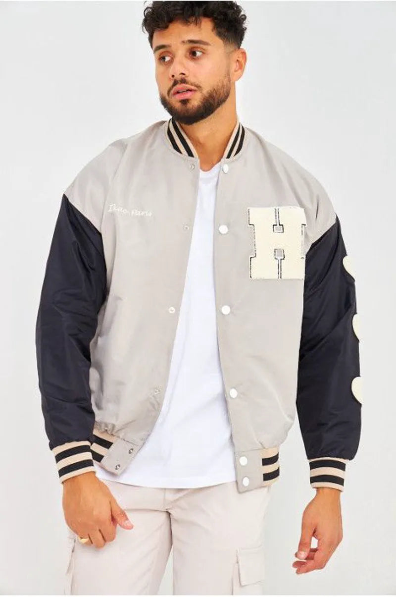 Gray bomber jacket with black sleeves embroidered with "parisian brand"